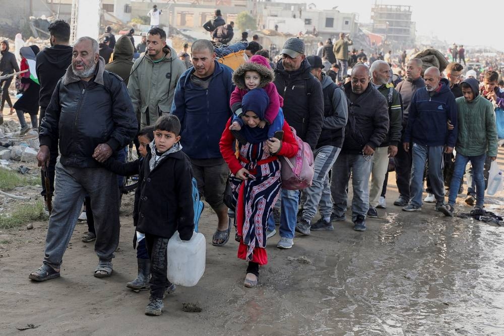 Palestinians, who were displaced to the south at Israel's order during the war, make their way on foot as they return to their homes in the northern Gaza, on Monday. REUTERS