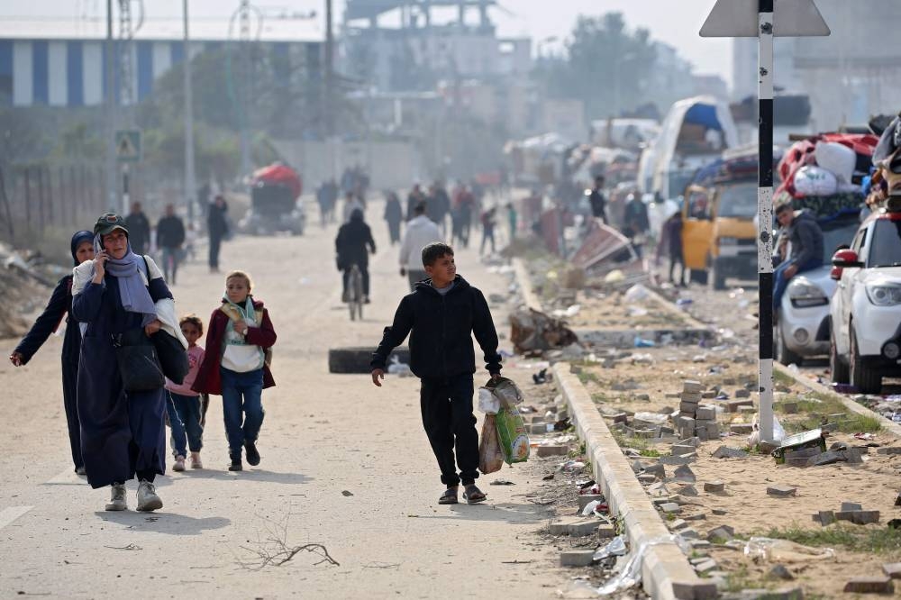 Palestinians walk along Salah al-Din road in Nuseirat as displaced as they make their way to the northern part of the Gaza strip on Tuesday. AFP
