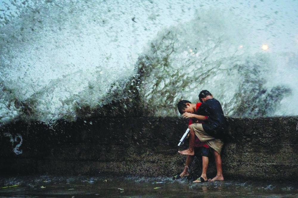
Children play near strong waves from the Pasig River amid Super Typhoon Man-yi, in Manila, last November. (Reuters) 