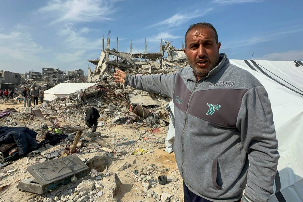 A Palestinian man, who was displaced at Israel's order during the war, reacts after returning to his destroyed house, in Jabalia refugee camp in the northern Gaza Strip, on Wednesday. REUTERS