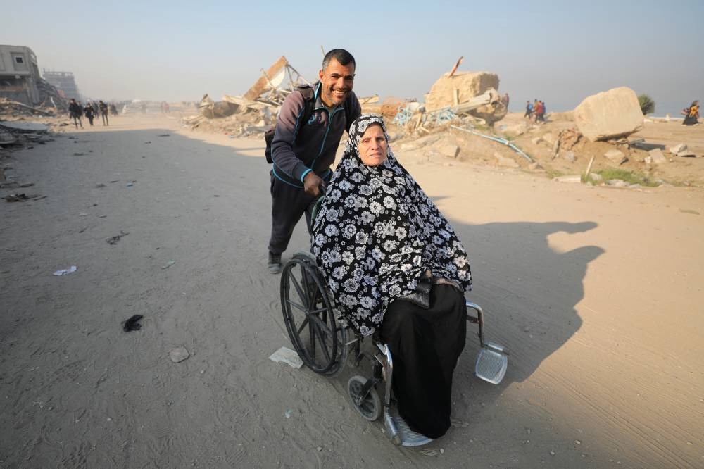 Palestinians, who were displaced to the south at Israel's order during the war, make their way as they return to their homes in northern Gaza, in Gaza City, on Wednesday. REUTERS