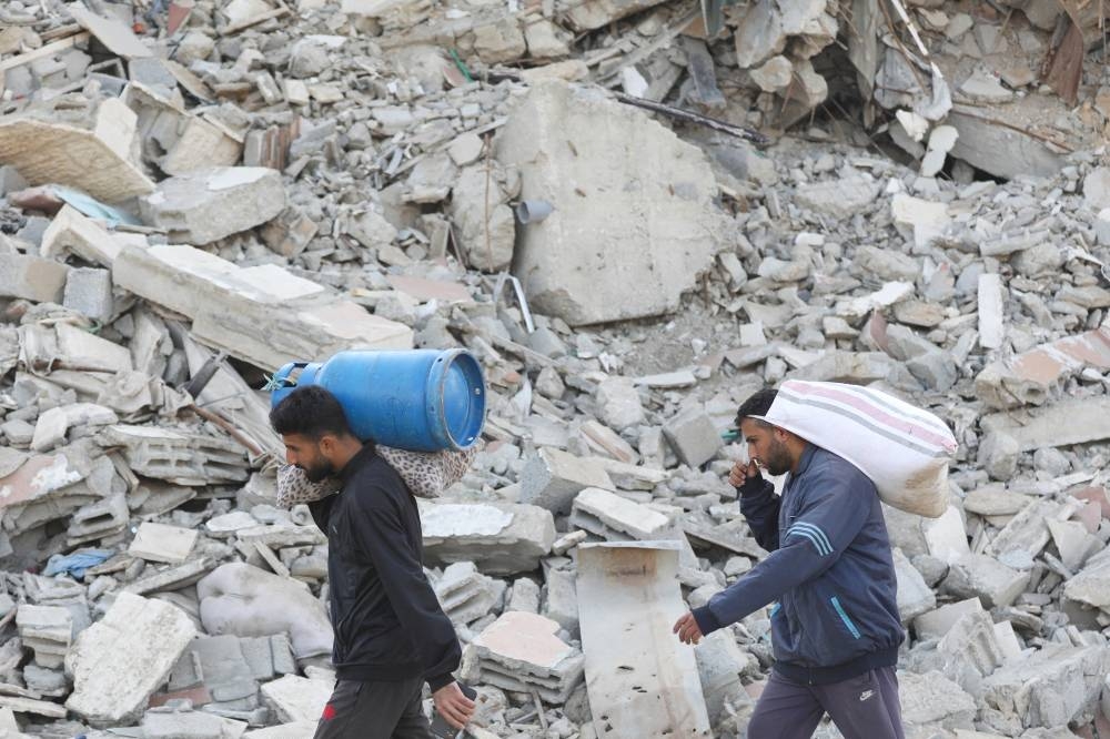 Palestinians, who were displaced to the south at Israel's order during the war, make their way as they return to their homes in northern Gaza, in Gaza City, on Wednesday. REUTERS