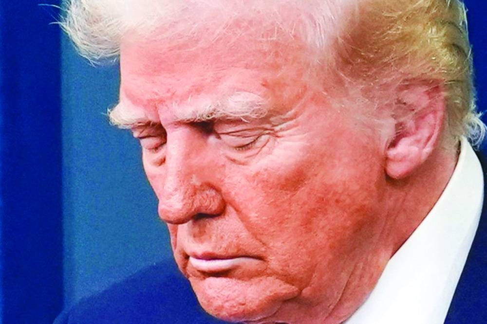 
US President Donald Trump pauses for a moment of silence to recognise crash victims as he speaks to reporters about the deadly midair collision. (Reuters) 