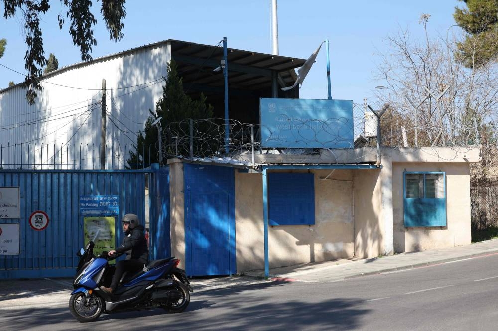 A man rides a motorbike past the gate of the United Nations Relief and Works Agency - UNRWA's West Bank Field Office in Jerusalem on Wednesday. AFP