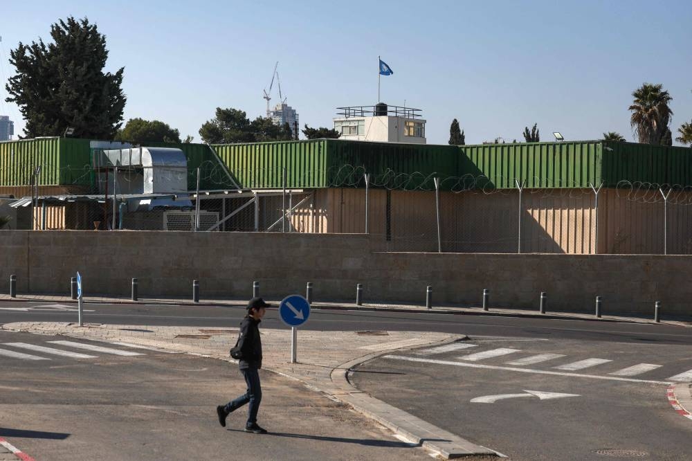 A youth walks in front of the United Nations Relief and Works Agency - UNRWA's West Bank Field Office in Jerusalem on Wednesday. AFP