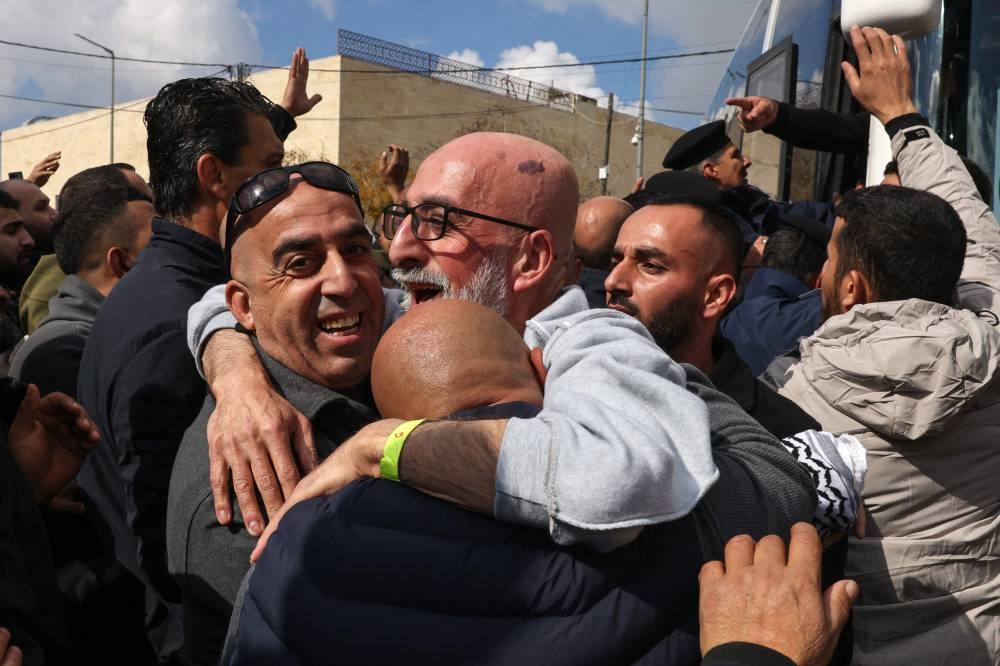 A former Palestinian prisoner released by Israel is is hugged by relatives upon his arrival in Ramallah on buses of the International Committee of the Red Cross (ICRC) on Saturday. AFP