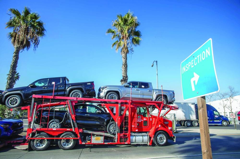 A truck carrying vehicles drives into the United States at the Otay Mesa Port of Entry, on the US-Mexico border Saturday.