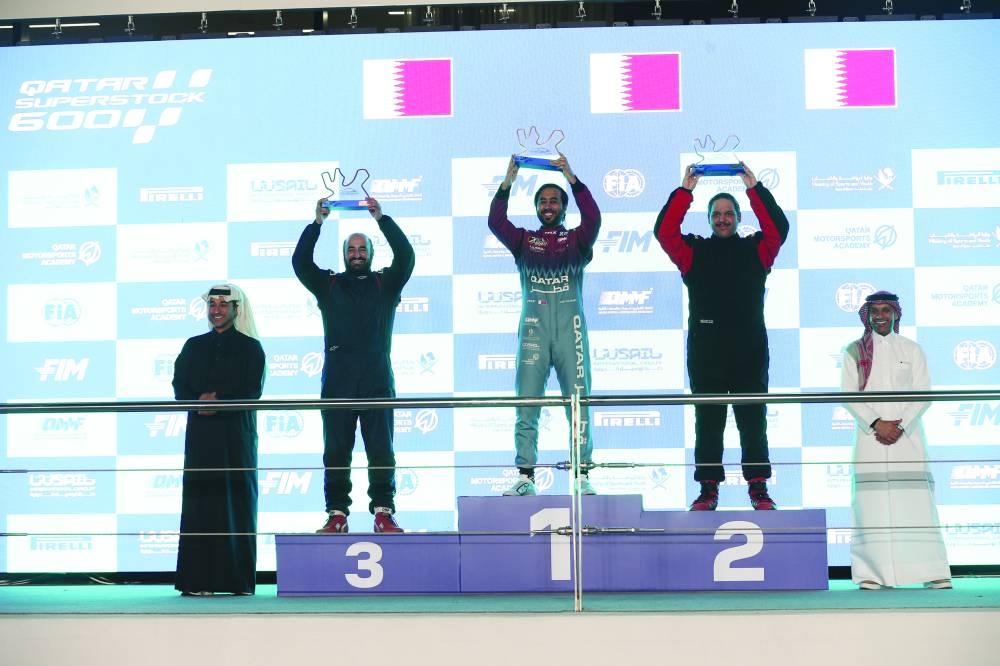 QTCC champion Abdulla al-Khelaifi poses with runner-up Ali Emadadhi and third-placed Ahmed al-Asiri on the podium at the Lusail International Circuit on Saturday. QMMF’s Executive Director Amro al-Hamad and QMMF senior committee member Abdulrazaq al-Kuwari presented the trophies to the winners.