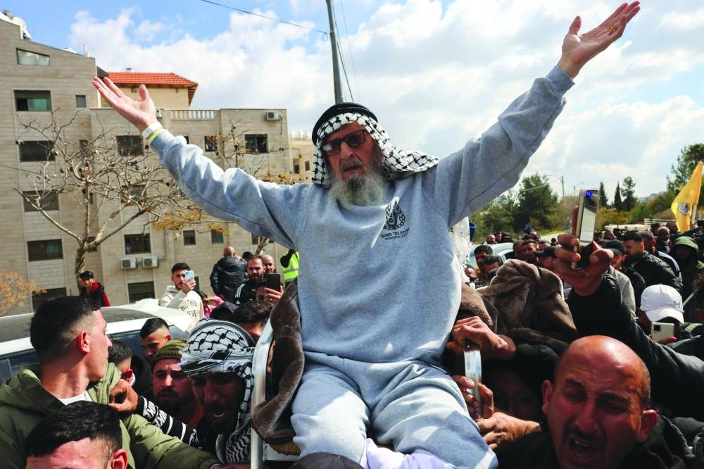 
A former Palestinian prisoner released by Israel is cheered upon his arrival in Ramallah on buses of the International Committee of the Red Cross (ICRC), yesterday. 