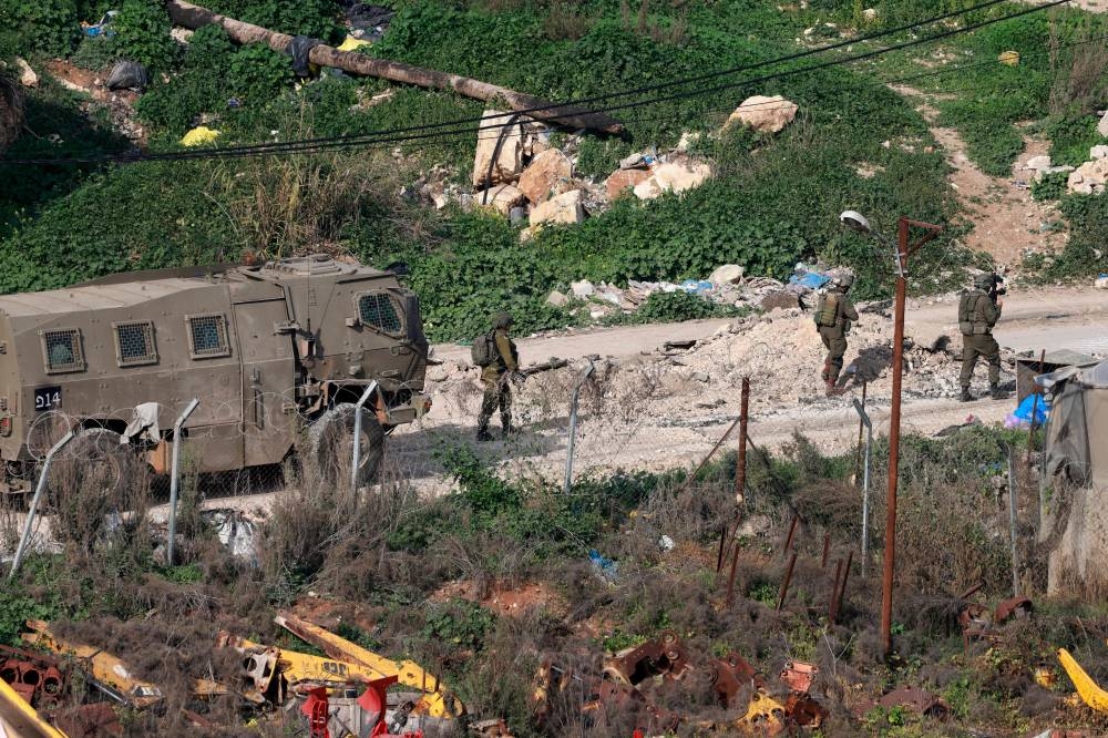 Israeli soldiers walk along a road during a military raid in the al-Fara camp for Palestinian refugees, south of Jenin in the occupied West Bank, on Sunday. REUTERS