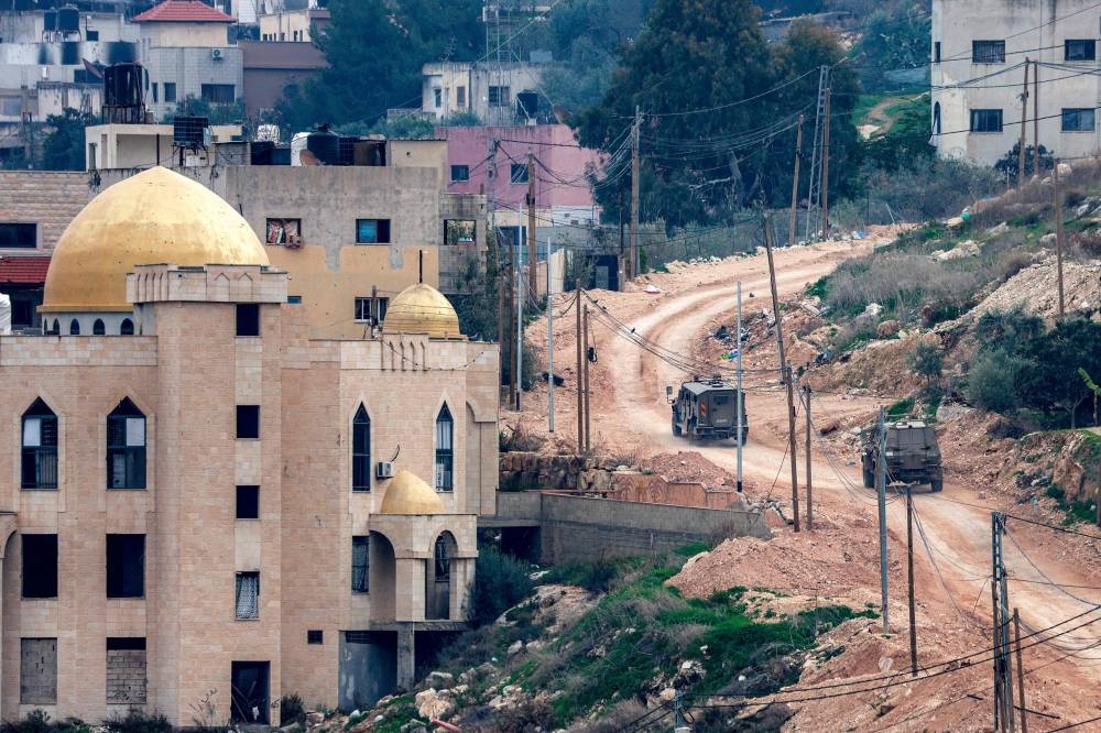 Israeli army armoured vehicles move along a road during a military operation in the Jenin camp for Palestinian refugees in the north of the occupied West Bank on Monday. AFP