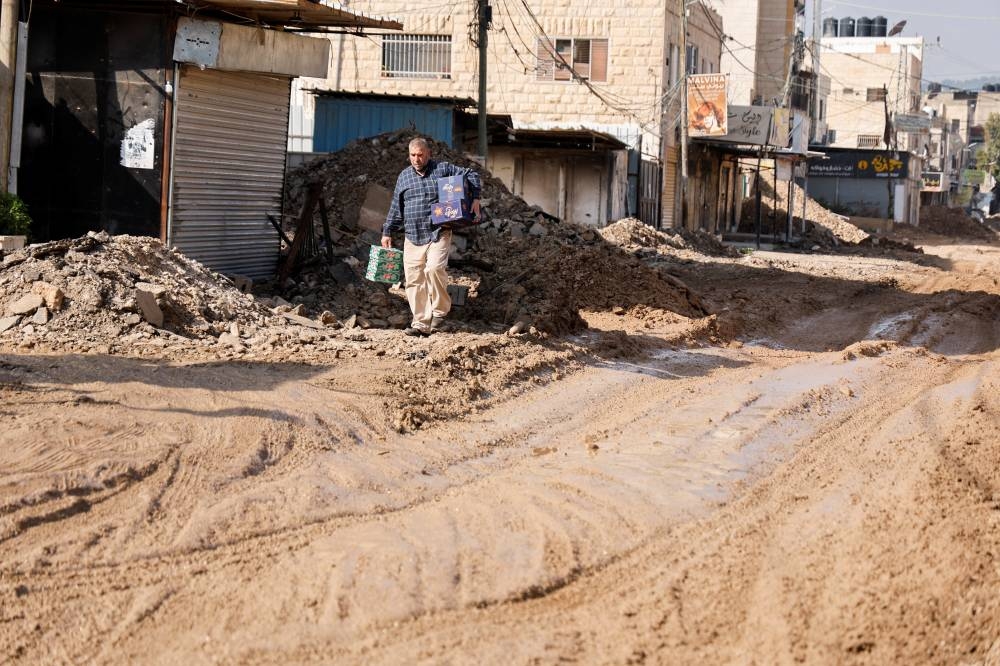 A Palestinian walks next to the rubble on a damaged road during an Israeli raid, in Jenin, in the Israeli-occupied West Bank, on Sunday. REUTERS