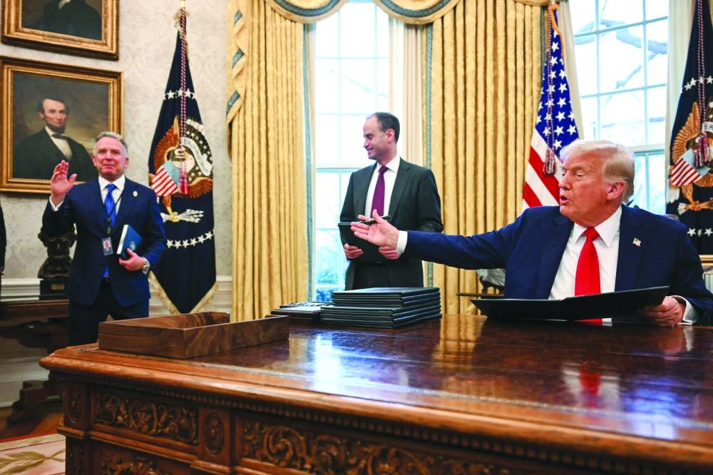 
US President Donald Trump gestures to US Special Envoy to the Middle East Steve Witkoff (left) as he signs an executive order to create a US sovereign wealth fund, in the Oval Office of the White House, on Monday. (AFP) 