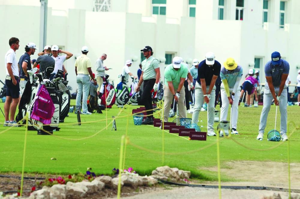 
Players practice at Doha Golf Club’s driving range before the start of their round. 