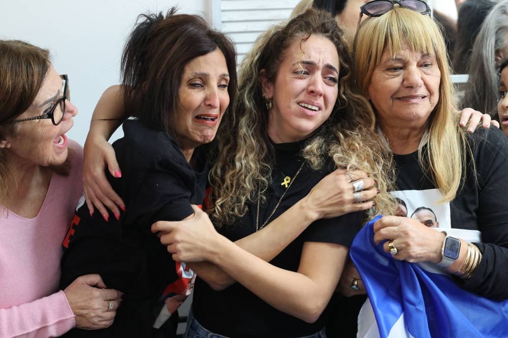 Close relatives of Israeli hostage Eli Sharabi react as they watch on a television screen his release along with two other hostages in the Gaza Strip, at the family home in Tel Aviv, on Saturday. AFP