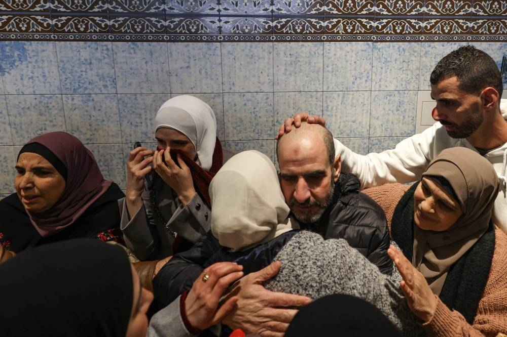 A former Palestinian prisoner is embraced by a family member after stepping out of a bus in the occupied West Bank city of Ramallah, on Saturday. AFP