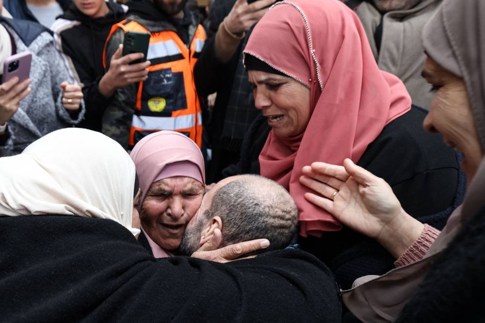 A former Palestinian prisoner is embraced by family members after stepping out of a bus in the occupied West Bank city of Ramallah, on Saturday. AFP