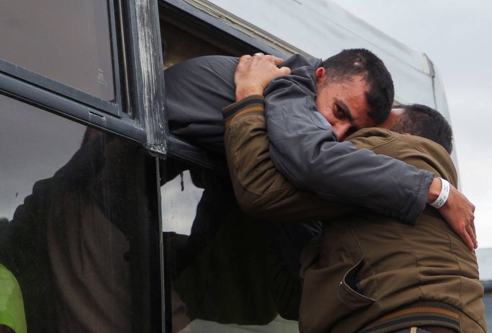 People hug each other as Palestinian prisoners are greeted after being released from an Israeli jail, in Khan Younis in the southern Gaza Strip, on Saturday. REUTERS