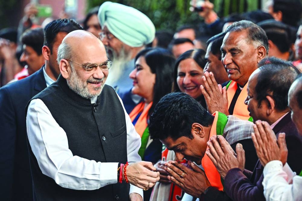 
India’s Home Minister and Bharatiya Janata Party leader Amit Shah (L) greets party members after election win. 