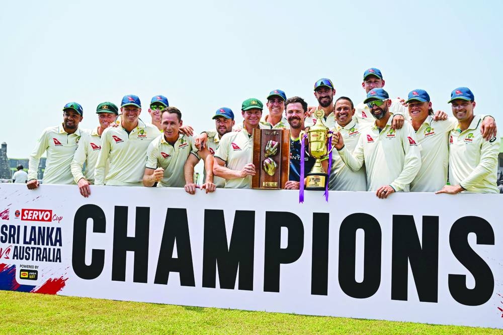 Australia’s players pose with the trophy after their win at the end of the second Test against Sri Lanka at the Galle International Cricket Stadium in Galle yesterday. Australia won the second Test by nine wickets to sweep the series 2-0. (AFP)