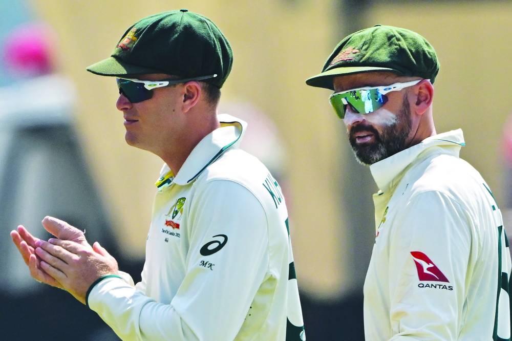 Australia’s Nathan Lyon (right) and Matthew Kuhnemann walk back to the pavilion at the end of the Sri Lanka innings yesterday. (AFP)