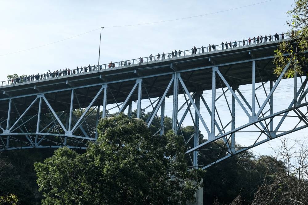 People stand on a bridge, in the aftermath of a deadly bus crash, in Guatemala City, Guatemala, on Monday. REUTERS