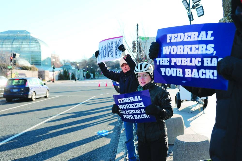Protesters hold signs on Independence Avenue near a protest in support of federal workers outside of the US Department of Health and Human Services, in Washington, DC. Organisers held the protest to speak on the Department of Government Efficiency (DOGE) cuts. – AFP