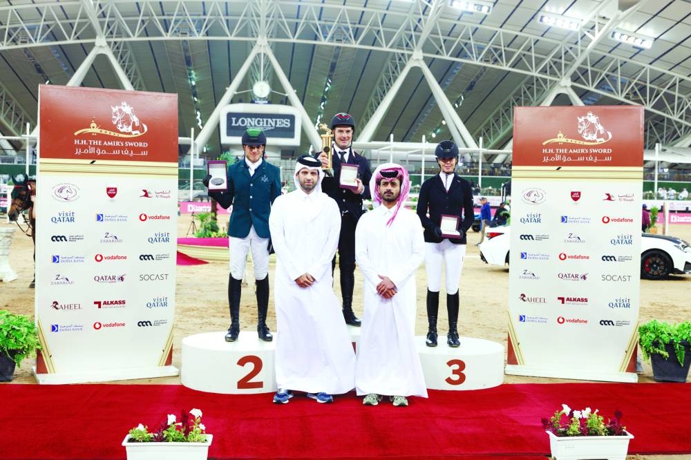 Sheikh Mohammed bin Fahad al-Thani, representing Doha Bank, and Sheikh Ahmad bin Nooh al-Thani, Secretary-General of Qatar Equestrian Federation and Member of the Organising Committee, pose with the podium winner of the CSI5* - Faults & Time - 1.50m class on day two of the HH The Amir Sword Equestrian Festival at Al Shaqab on Friday. Emanuele Gaudiano won the event, with Abdullah Alsharbatly and Ellen Whitaker finishing second and third, respectively.