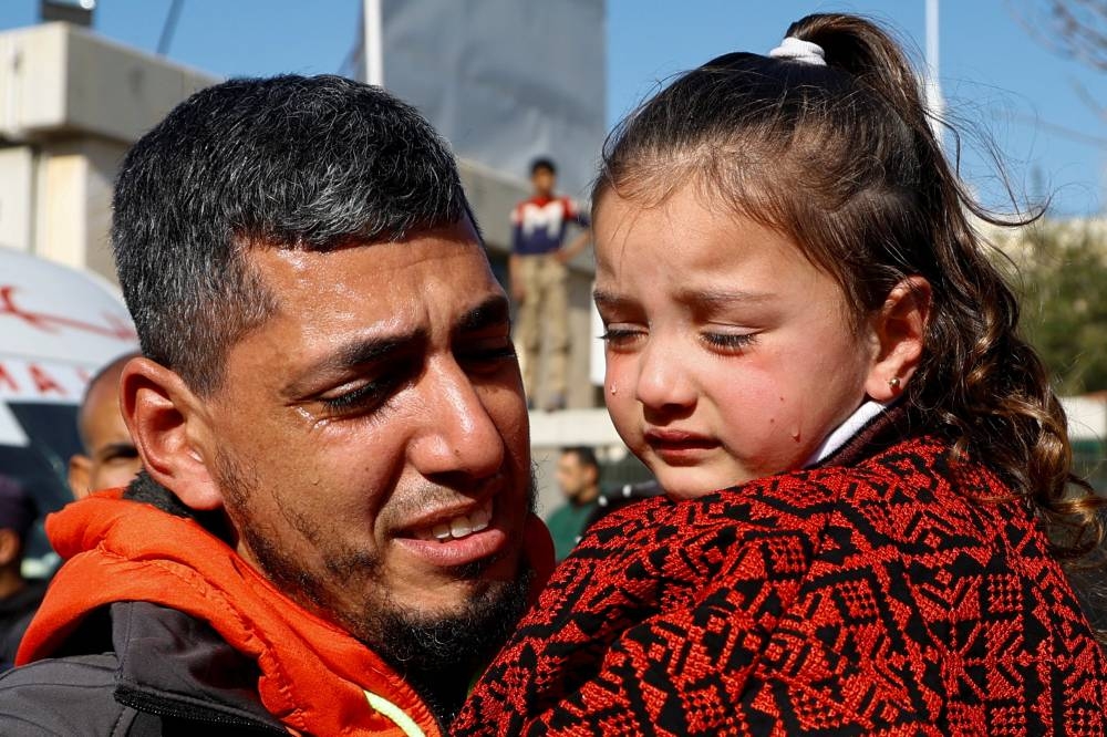 A freed Palestinian prisoner holds a child after being released by Israel, in Khan Younis, in the southern Gaza Strip, on Saturday. REUTERS