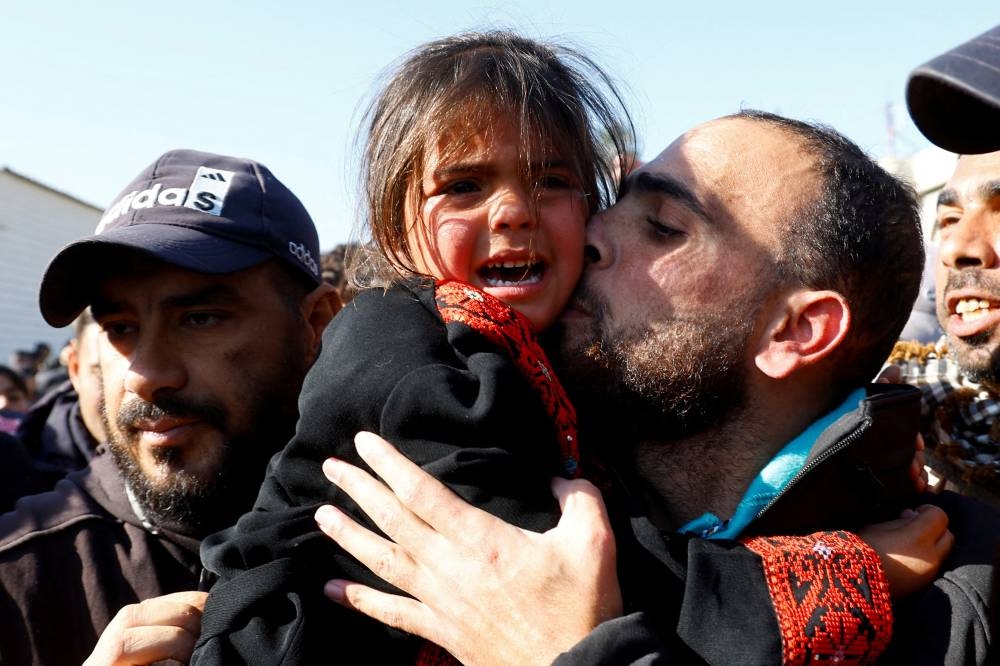 A freed Palestinian prisoner holds a child after being released by Israel, in Khan Younis, in the southern Gaza Strip, on Saturday. REUTERS