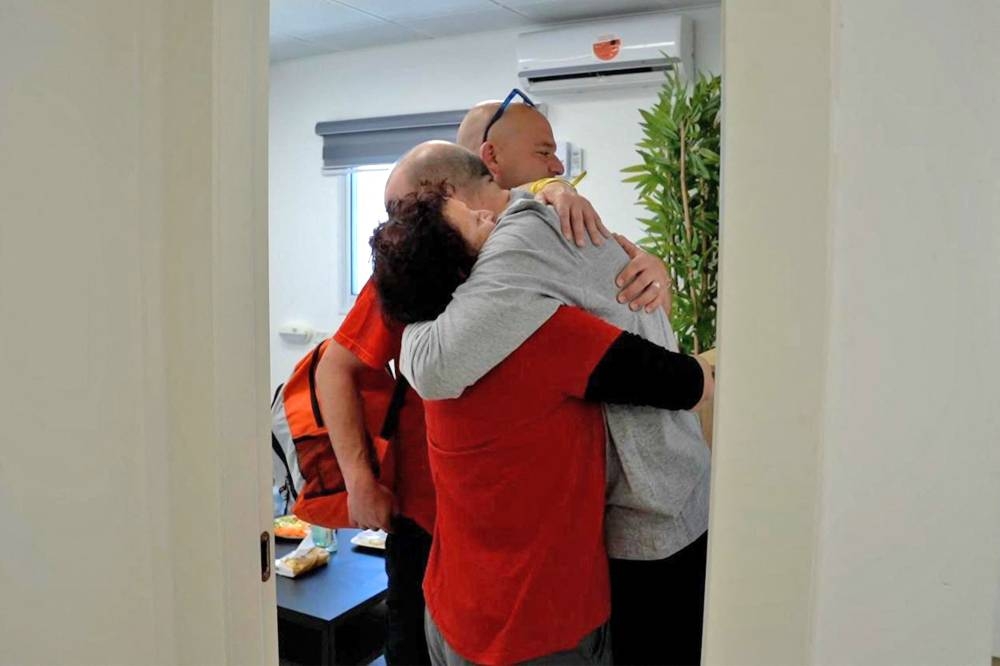 Newly-released hostage Yair Horn (C), reunited with his mother and brother at an unspecified location in Israel on Saturday. AFP