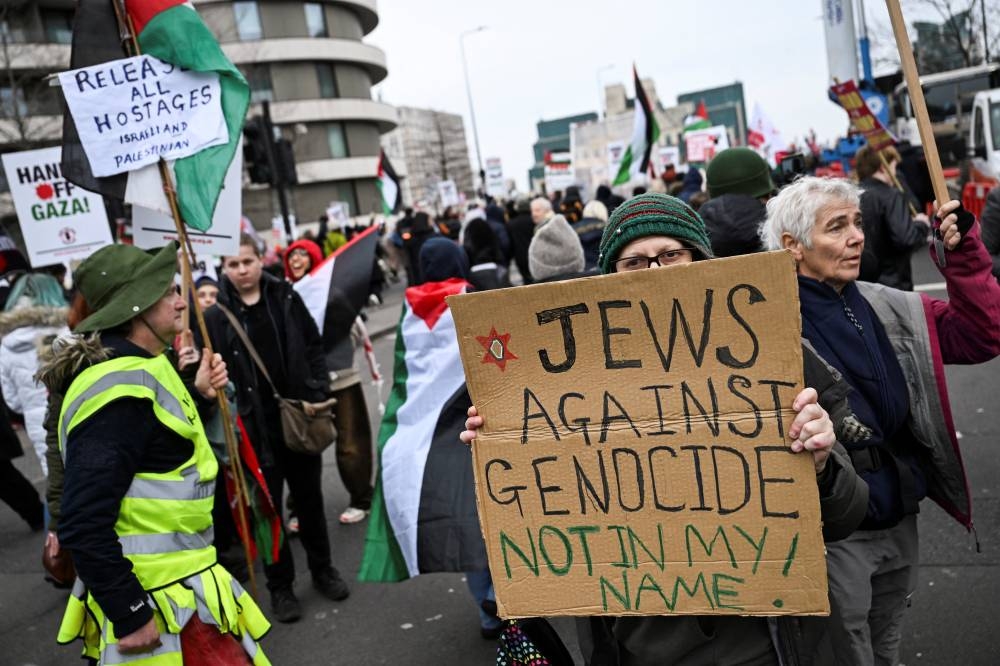 A pro-Palestinian demonstrator holds a banner during a march in opposition to US President Donald Trump's plan to displace Palestinians from Gaza and "take over" the territory, in London, on Saturday. REUTERS