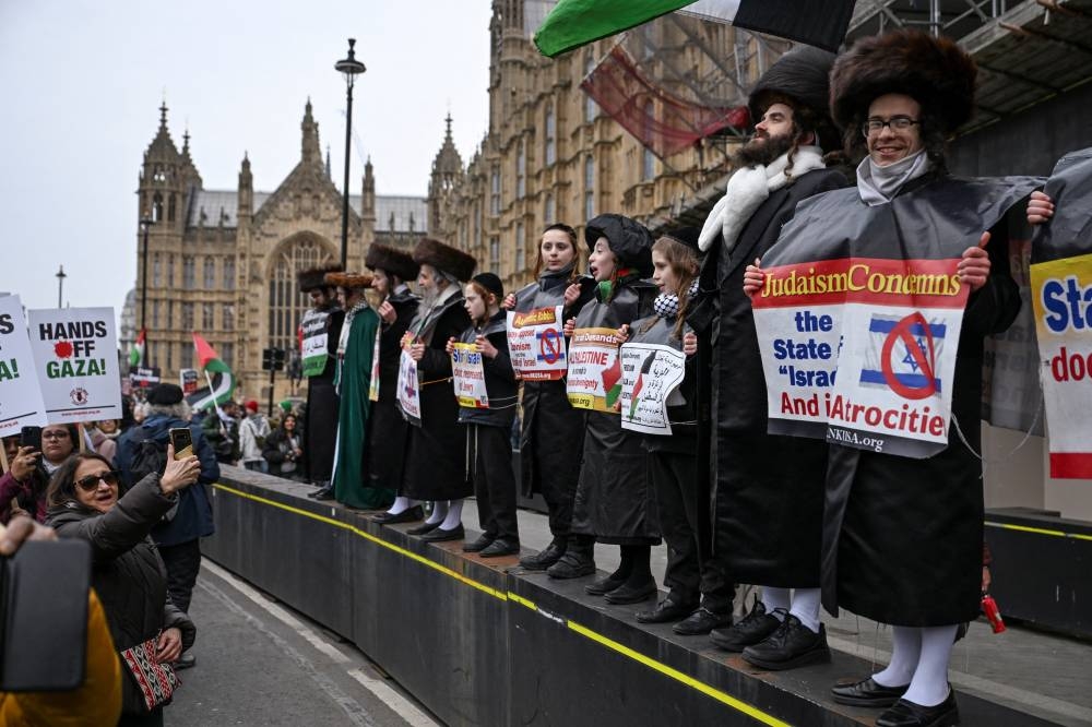 Pro-Palestinian demonstrators wearing ultra-Orthodox Jewish clothing participate in a march in opposition to US President Donald Trump's plan to displace Palestinians from Gaza and "take over" the territory, in London, on Saturday. REUTERS