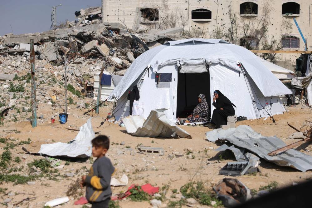 Palestinian women sit outside their tent in Jabalia in the northern Gaza Strip, on Monday. AFP