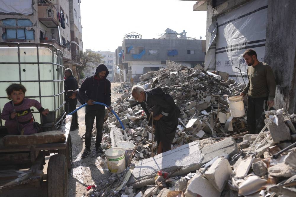 A Palestinian fills a bucket with drinking water in Jabalia in the northern Gaza Strip, on Monday. AFP
