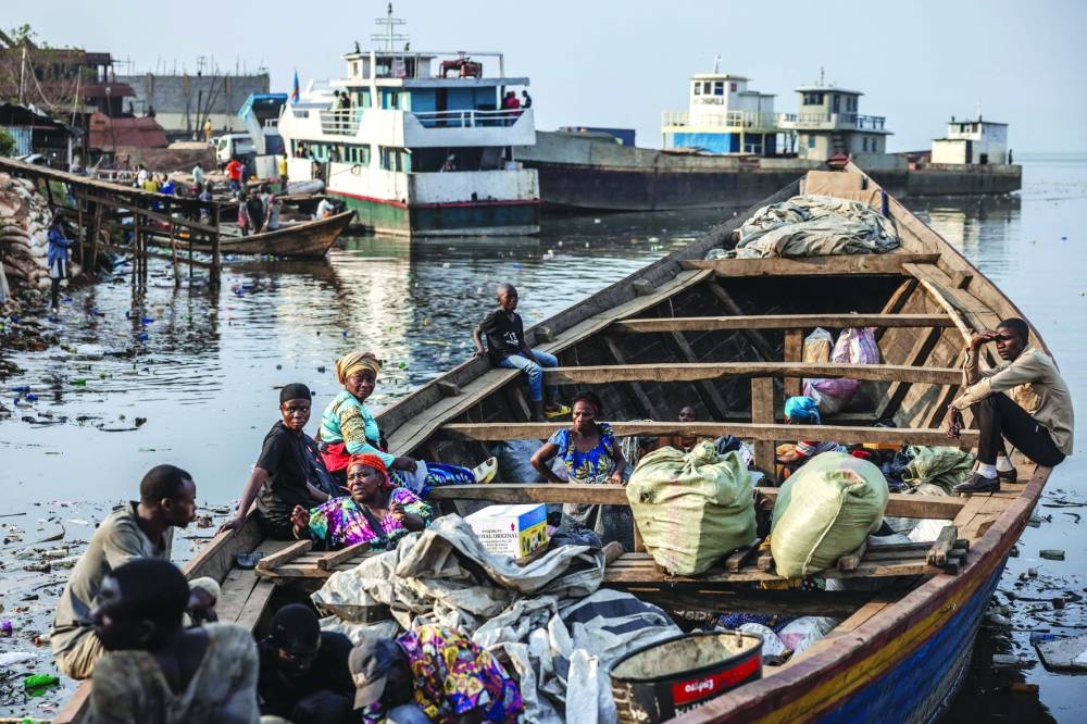 Families wait in a boat with their belongings for departure to Minova from a pirogue dock on the shores of Lake Kivu.