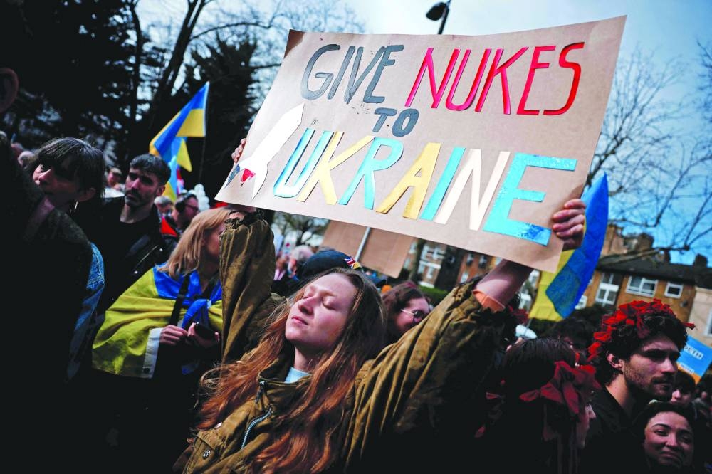 
A protester holds a placard reading “Give nukes to Ukraine” as people gather in central London yesterday for a march in support of Ukraine ahead of the third anniversary of the war. 