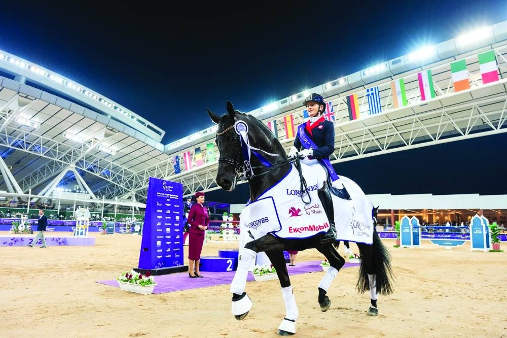 
Poland’s Sandra Sysojeva takes a lap of honour with her black mare Maxima Bella after winning the CDI5 - Grand Prix Freestyle. 