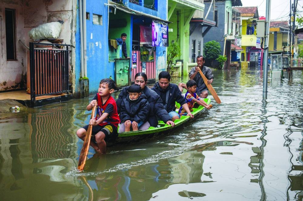 
Residents use a wooden boat to navigate a flooded road after heavy rain in Dayeuhkolot village, Bandung, West Java, on Wednesday. (AFP) 