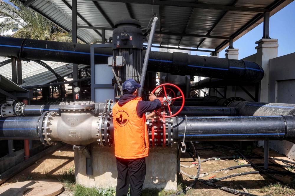 A worker turns a valve at the Southern Gaza Desalination plant, which stopped working earlier after Israel cut off electricity supply to the Gaza Strip, in Deir el-Balah in the centre of the Palestinian territory on Monday. AFP