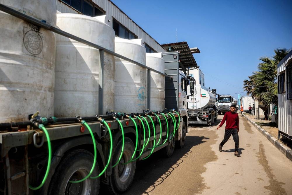 Tanker trucks and others carrying cisterns move to fill up water at the Southern Gaza Desalination plant, which stopped working earlier after Israel cut off electricity supply to the Gaza Strip, in Deir el-Balah in the centre of the Palestinian territory on Monday. AFP