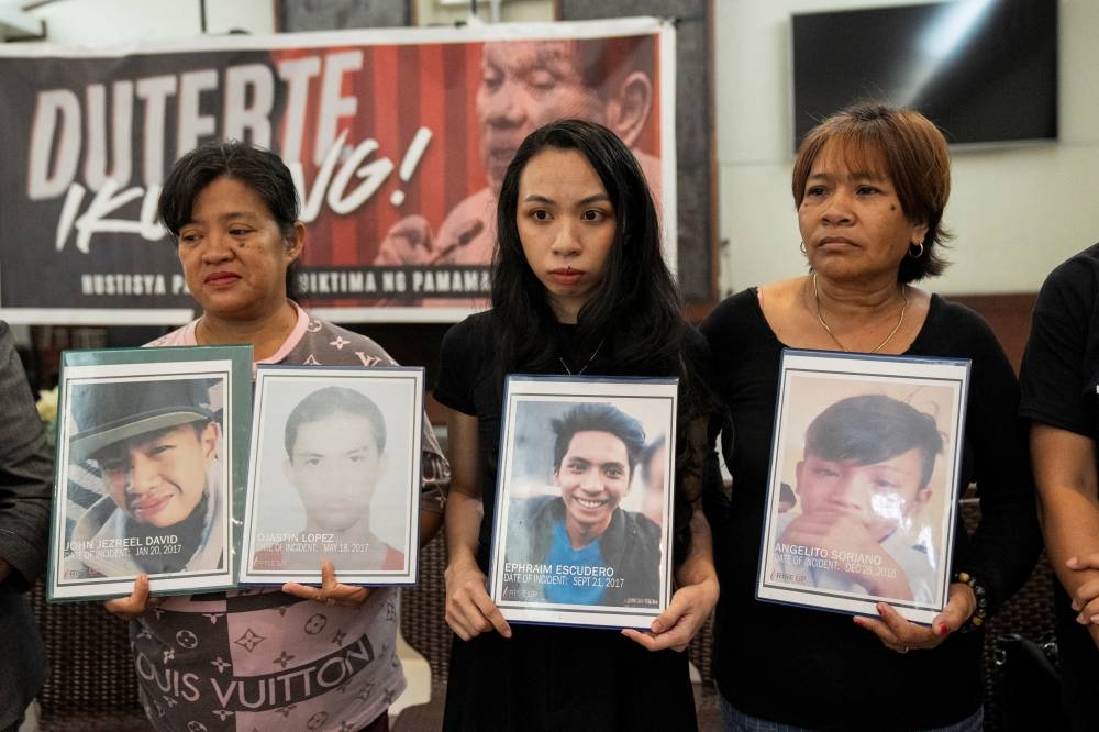 Relatives hold pictures of drug war and extrajudicial killing victims during a press conference following the arrest of former Philippine President Rodrigo Duterte, in Quezon City, Metro Manila, Philippines, on Wednesday. REUTERS