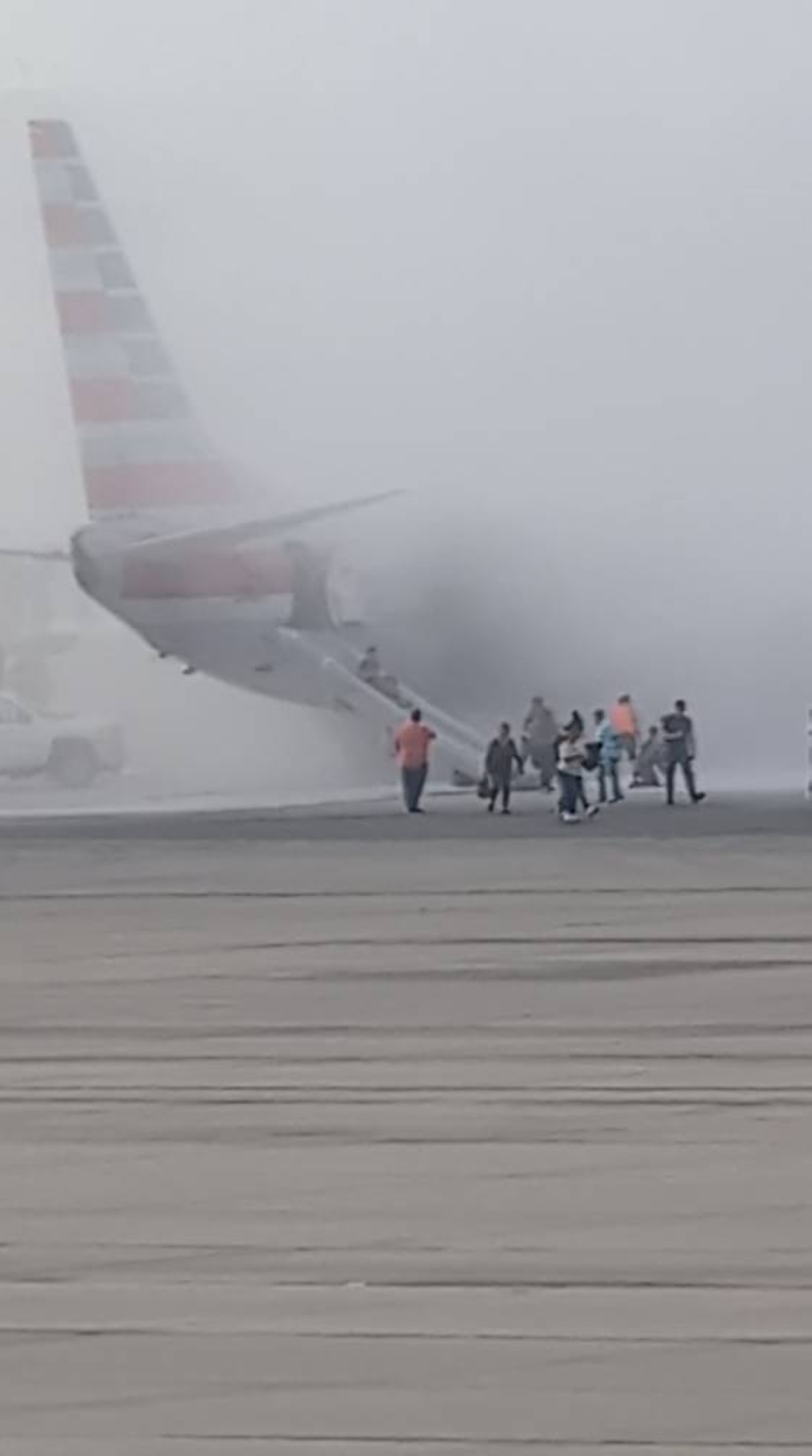 Smoke rises as a passenger gets evacuated using the plane's slides, after an American Airlines jet engine caught fire, in Denver, Colorado, US, on Friday, in this screengrab obtained from a social media video. Aaron Clark/via REUTERS