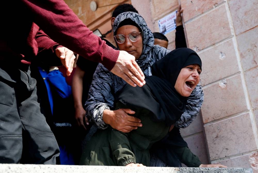 Mourners react next to the bodies of Palestinians killed in an Israeli strike, in the northern Gaza Strip on Saturday. REUTERS