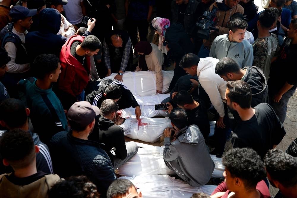 Mourners react next to the bodies of Palestinians killed in an Israeli strike, in the northern Gaza Strip on Saturday. REUTERS