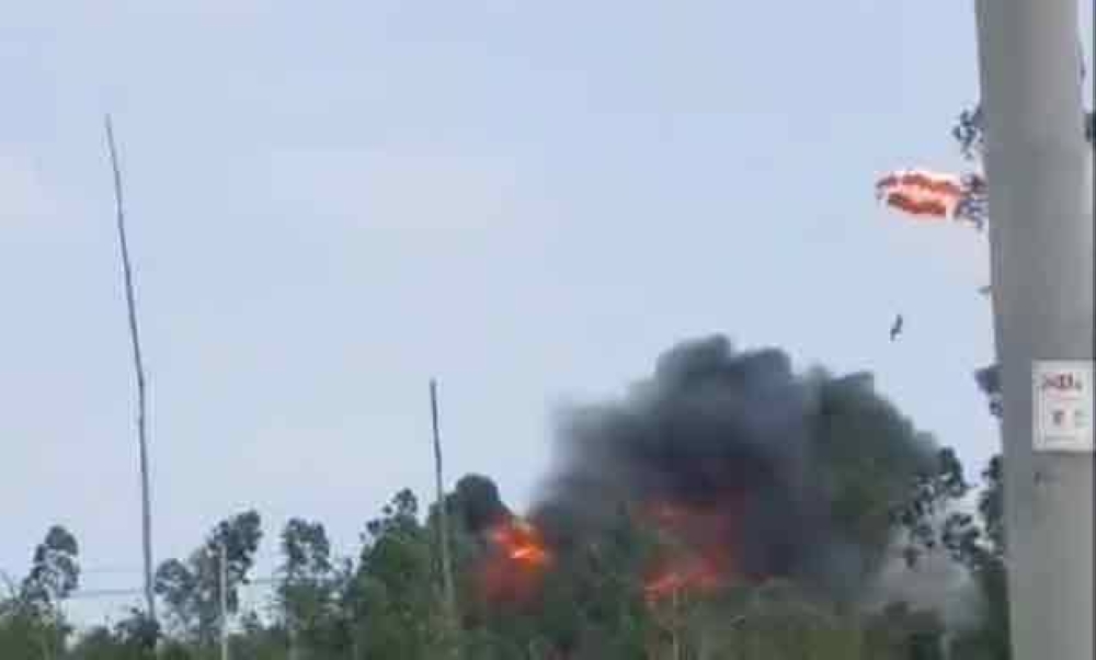 An image grab from a video being shared on social media that purportedly shows the pilot of the Chinese fighter jet ejecting with a parachute (seen on the right) while thick smoke and fire erupt from the crashed plane.