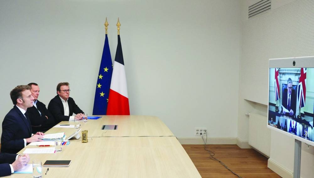 French President Emmanuel Macron (left) attends a videocall as he takes part in a virtual summit held by Starmer (on screen) and focused on peace and security in Ukraine, at the Elysee Palace in Paris. – AFP
