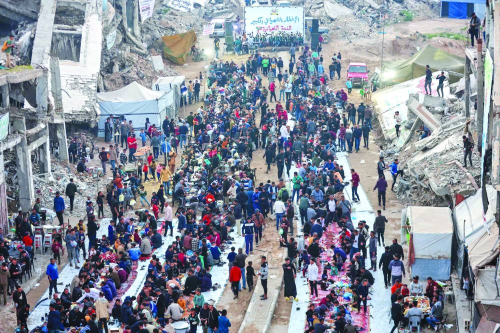 Palestinians gather for a mass fast-breaking Iftar meal amid the rubble of destroyed buildings in Beit Lahia in the northern Gaza Strip, yesterday.