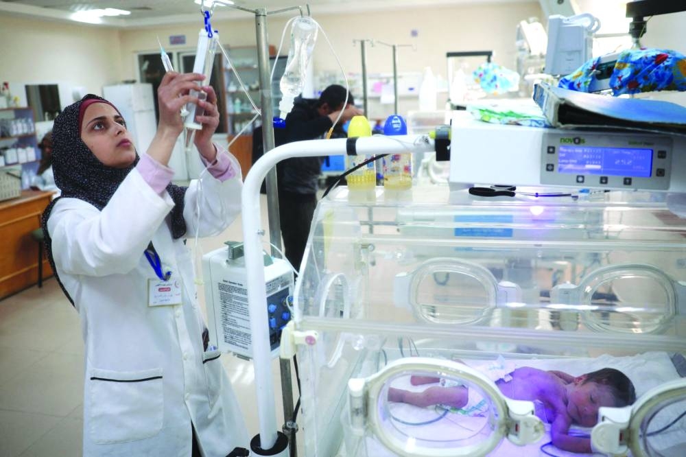 A nurse cares for a prematurely born baby lying inside an infant incubator at the Al-Aqsa Martyrs hospital in Deir el-Balah in the central Gaza Strip, yesterday, almost a week after Israel cut off the electricity supply from the Gaza Strip.