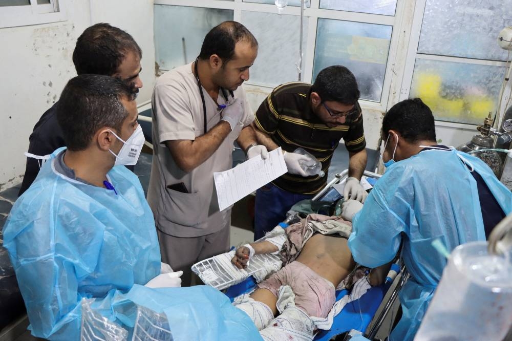 Medics attend to a girl injured by a US strike in Saada, Yemen, on Sunday. REUTERS